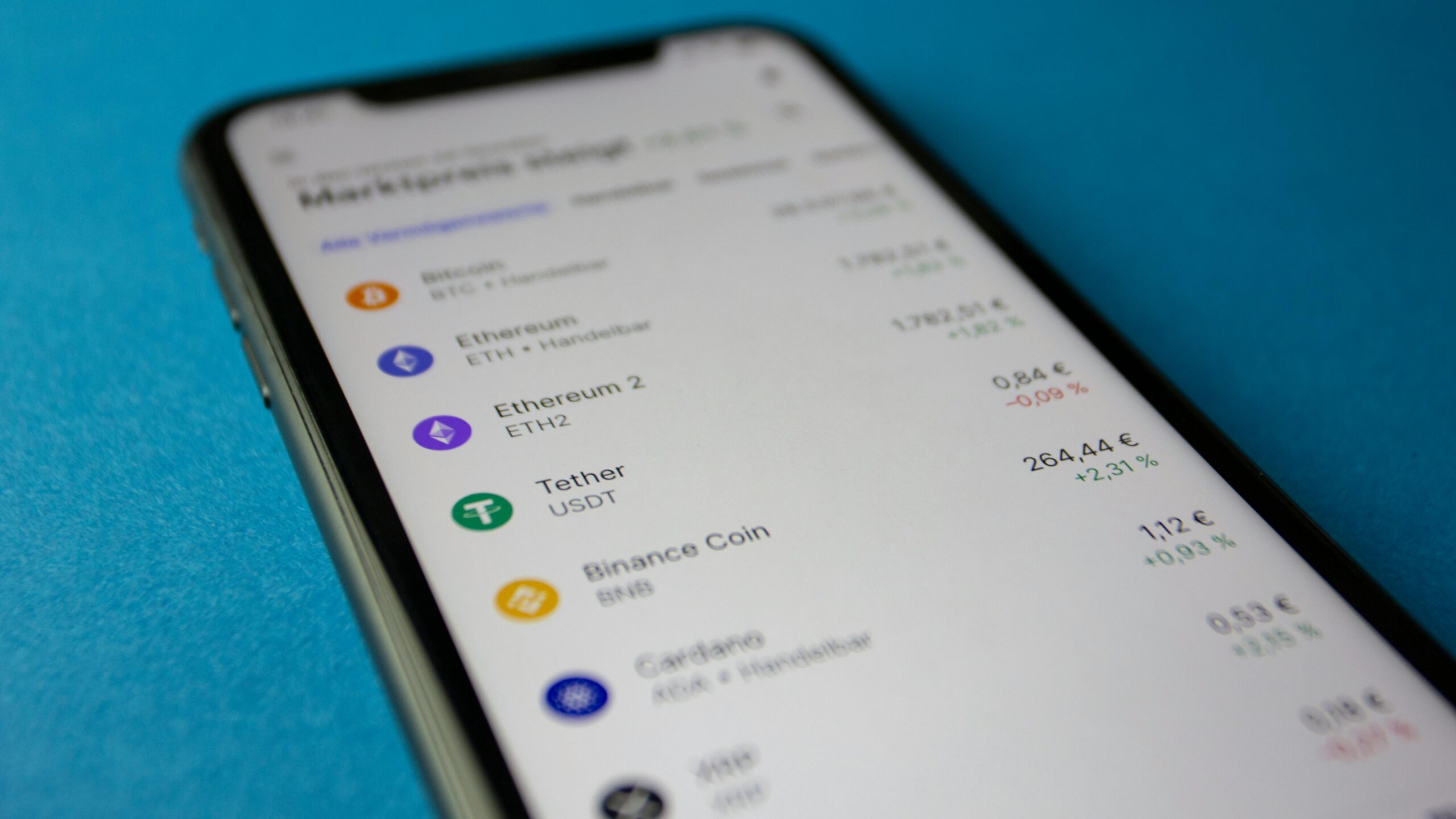 Close-up photo of a smartphone displaying cryptocurrency market data with price listings.